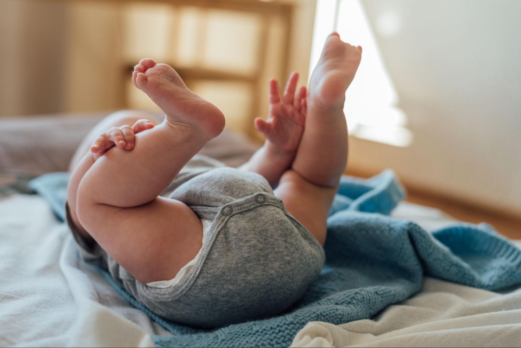 bebe se agarra los pies
